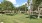 a large green lawn with trees and a building in the background