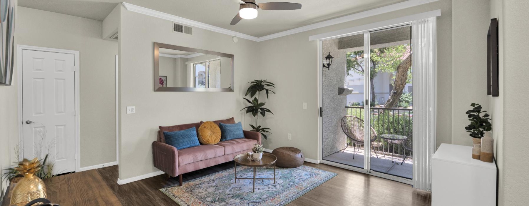 Living room with a couch and arcadia sliding glass door with view of the patio at The Catherine.