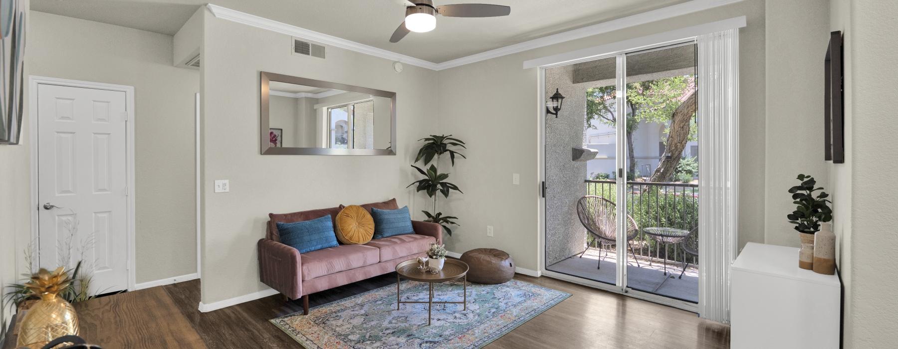 Living room with a couch and arcadia sliding glass door with view of the patio at The Catherine.