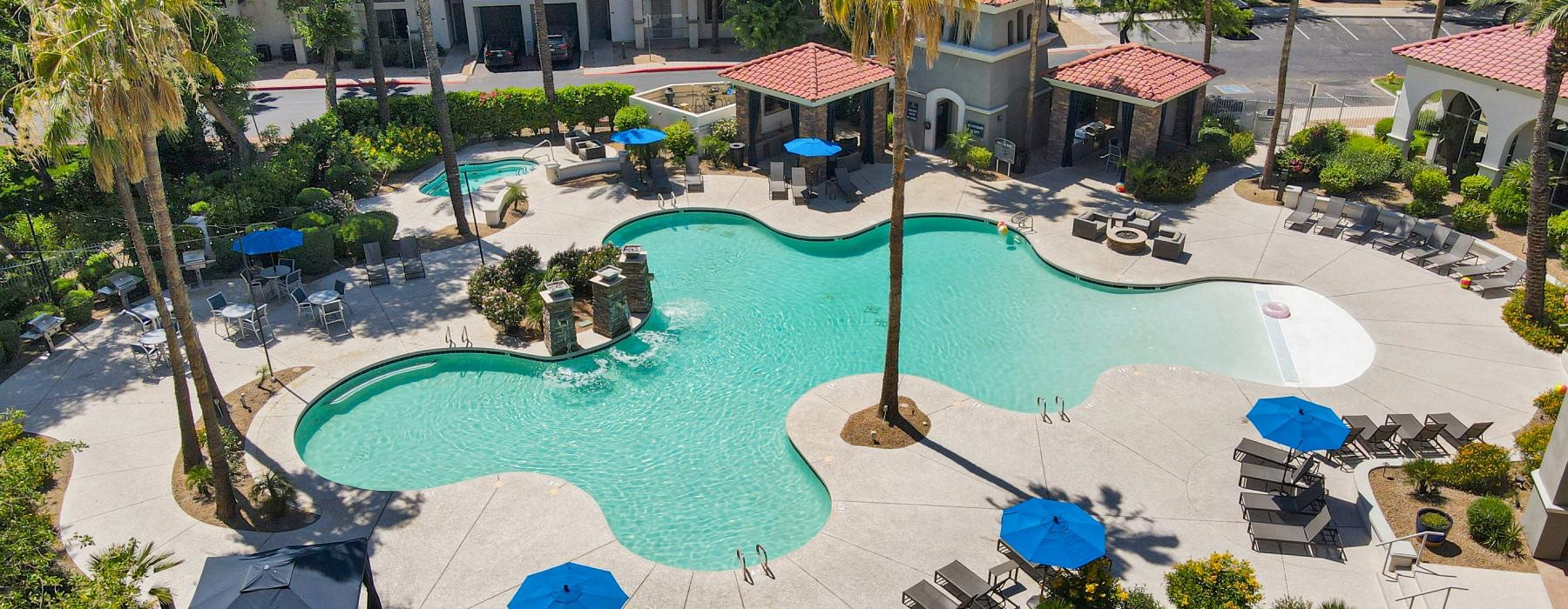 a pool with lounge chairs and umbrellas next to it