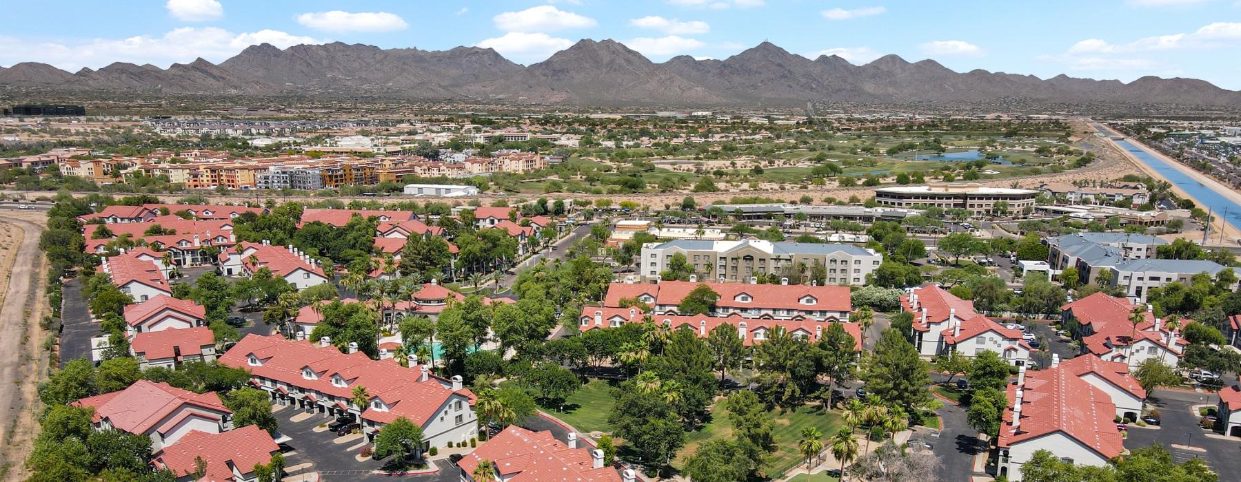 red roofed buildings with trees and a mountain range in the distance